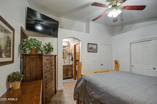 bedroom featuring ceiling fan, ensuite bath, and parquet floors