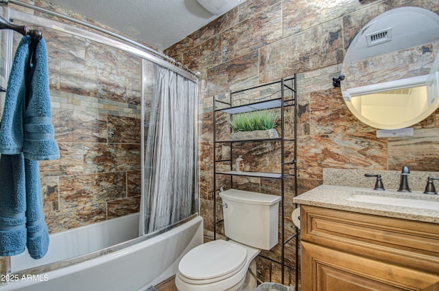 full bathroom featuring vanity, a textured ceiling, toilet, and shower / bath combo with shower curtain