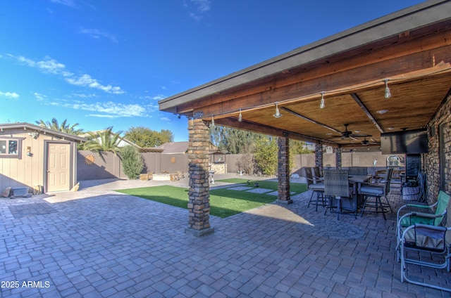 view of patio featuring ceiling fan and a shed