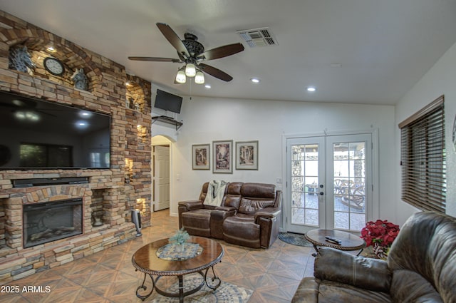 living room featuring lofted ceiling, a fireplace, french doors, and light parquet floors