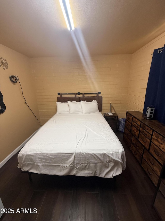 bedroom featuring wood finished floors and baseboards