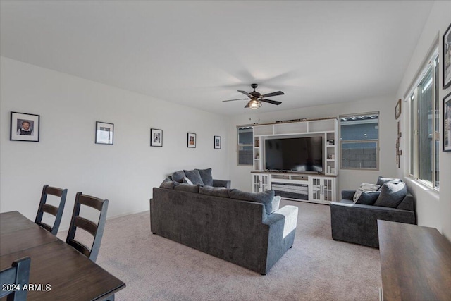 living room featuring carpet flooring, ceiling fan, and a fireplace