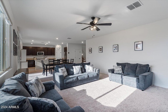 carpeted living room featuring ceiling fan and plenty of natural light