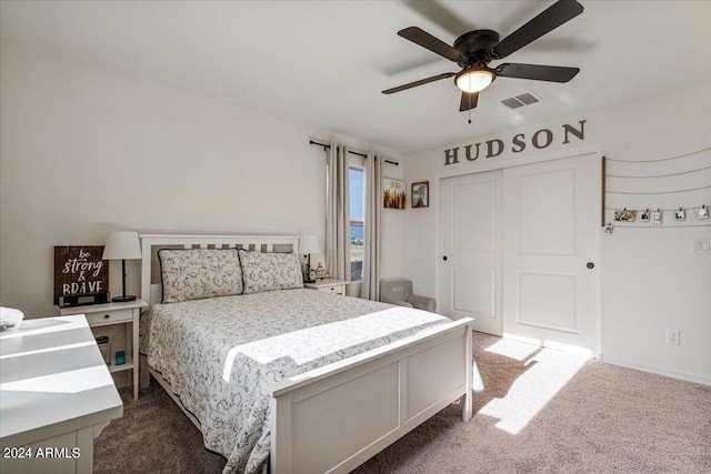 carpeted bedroom with ceiling fan and a closet