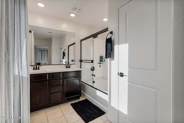 bathroom with combined bath / shower with glass door, vanity, and tile patterned floors