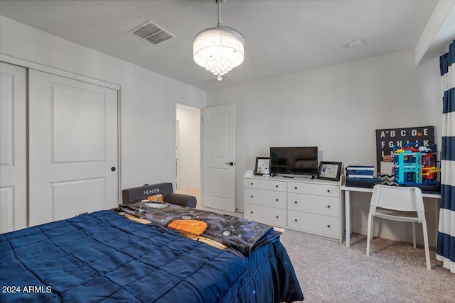 carpeted bedroom with a closet and a chandelier