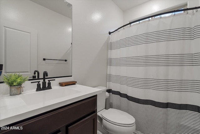 bathroom featuring vanity, toilet, and curtained shower