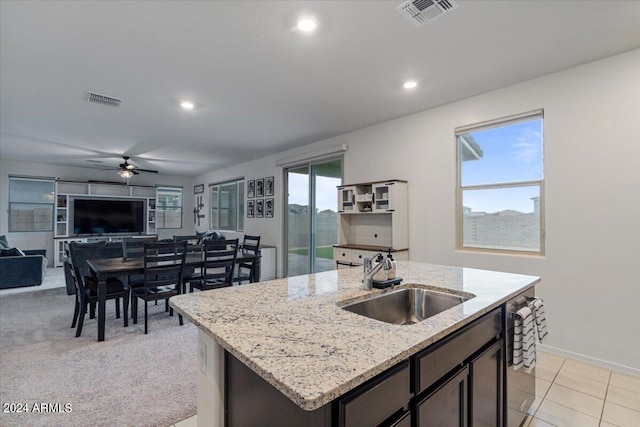 kitchen featuring light colored carpet, ceiling fan, sink, and a healthy amount of sunlight