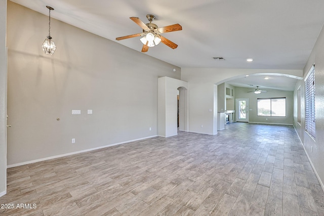 unfurnished living room featuring arched walkways, lofted ceiling, a ceiling fan, visible vents, and light wood-style floors