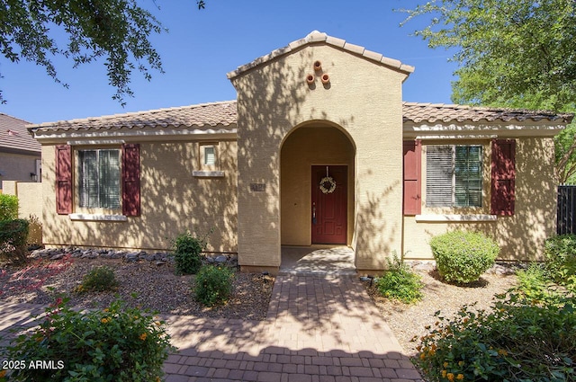 mediterranean / spanish-style house featuring stucco siding and a tiled roof