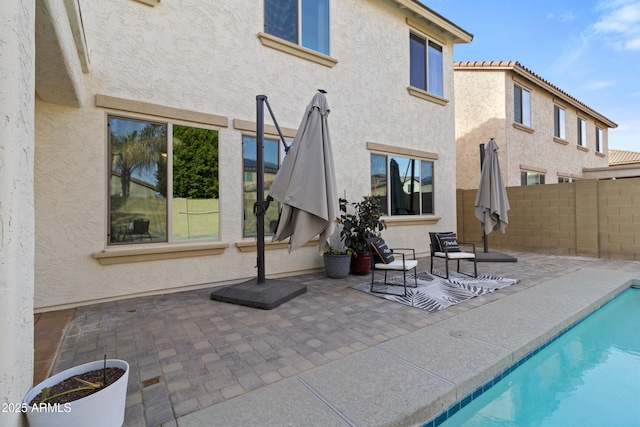 back of house featuring a fenced in pool and a patio area