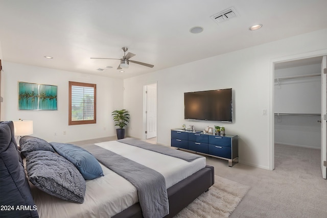 carpeted bedroom with ceiling fan, a spacious closet, and a closet