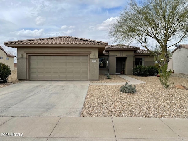 view of front facade with an attached garage, stucco siding, a tile roof, and concrete driveway
