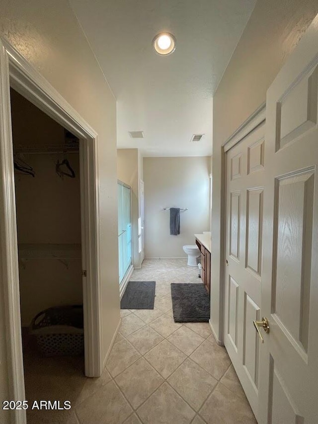 full bath featuring visible vents, a walk in closet, tile patterned flooring, and vanity