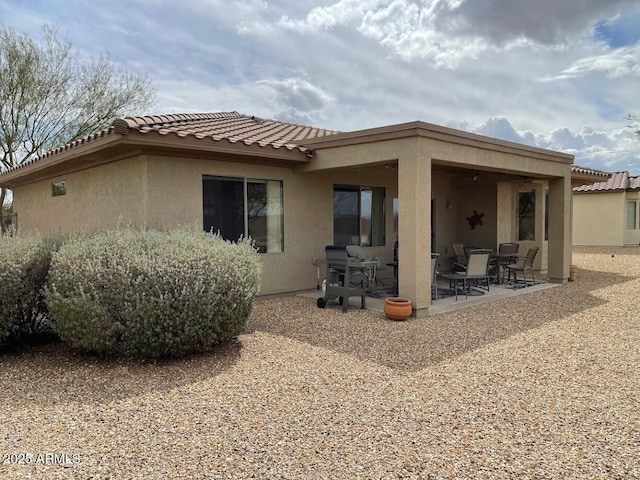 back of house featuring a patio, stucco siding, and a tile roof