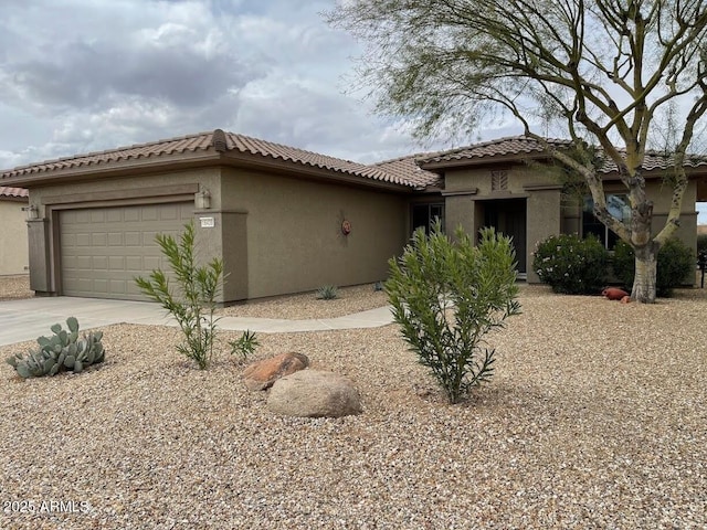 mediterranean / spanish-style home with a garage, stucco siding, and driveway