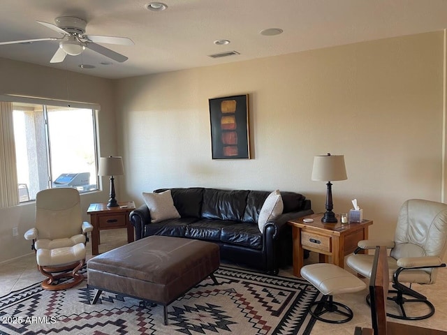 living area with a ceiling fan, visible vents, and light tile patterned floors
