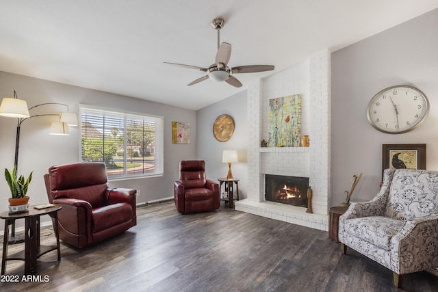 sitting room featuring ceiling fan, dark hardwood / wood-style flooring, vaulted ceiling, and a brick fireplace