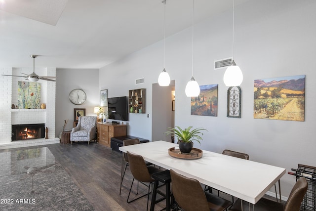 dining space with a fireplace, dark hardwood / wood-style floors, and ceiling fan