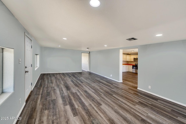 unfurnished living room with dark wood-style floors, recessed lighting, visible vents, and baseboards