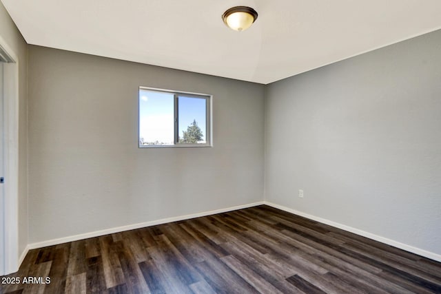 unfurnished room featuring dark wood finished floors and baseboards