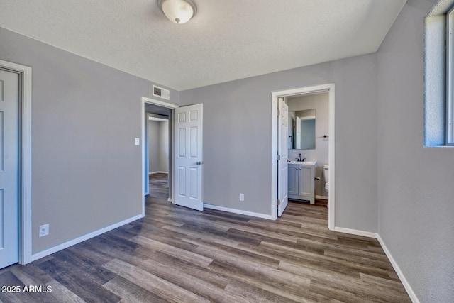 unfurnished bedroom with baseboards, visible vents, and dark wood finished floors