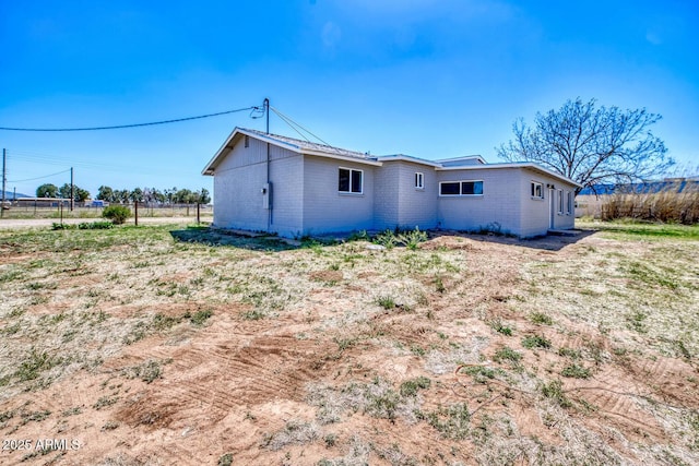 rear view of house featuring fence