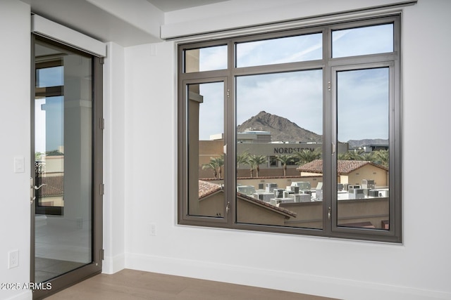 doorway to outside with a mountain view, wood-type flooring, and a wealth of natural light