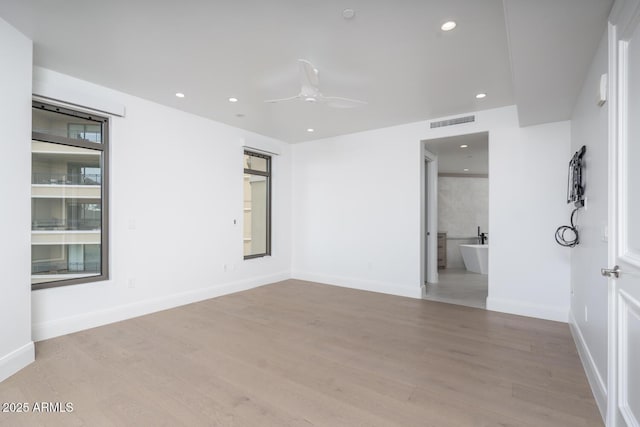 spare room featuring ceiling fan and light hardwood / wood-style flooring