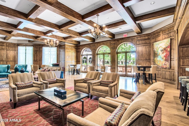 living room featuring light wood-type flooring, a notable chandelier, and wood walls