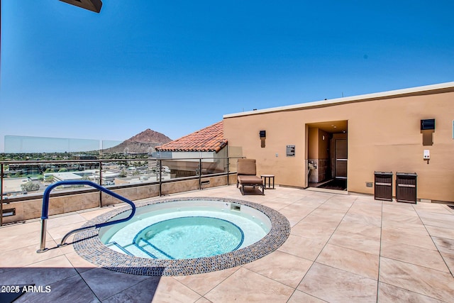 view of pool with a mountain view and an in ground hot tub