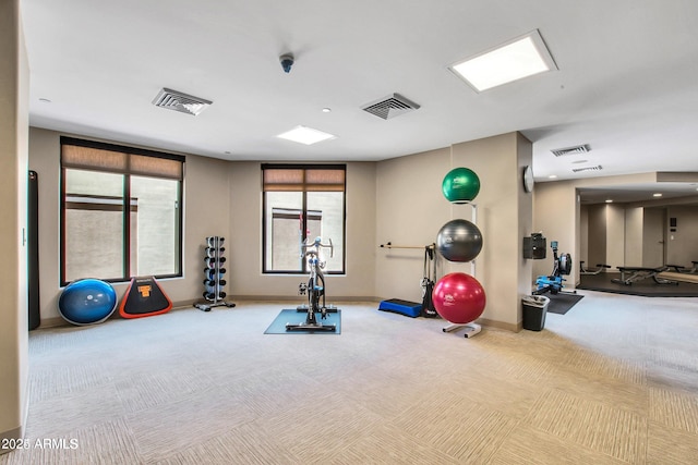 exercise room featuring light carpet