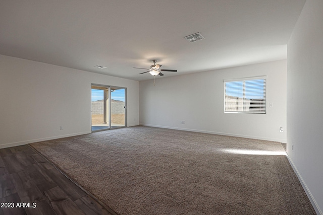 unfurnished room featuring dark hardwood / wood-style flooring, a wealth of natural light, and ceiling fan