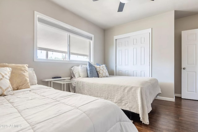 bedroom featuring a closet, ceiling fan, baseboards, and dark wood-style floors
