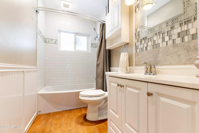 full bathroom with toilet, shower / bathtub combination with curtain, wood finished floors, and vanity