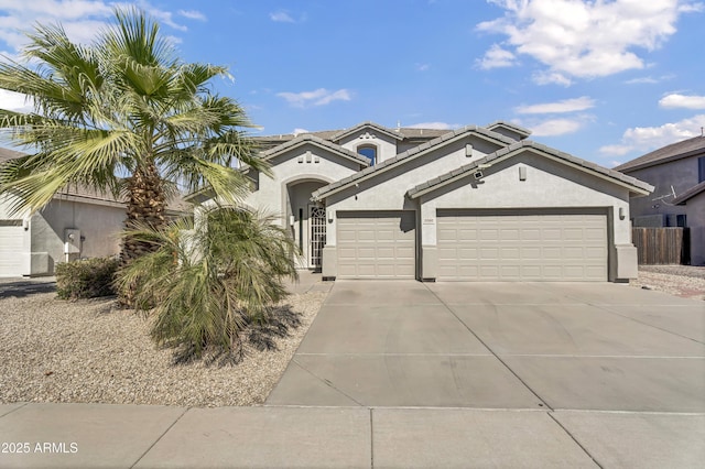 view of front of home featuring concrete driveway, a tiled roof, an attached garage, and stucco siding