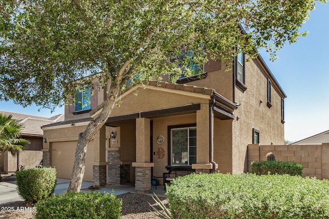view of front of house with driveway, covered porch, stucco siding, fence, and a garage