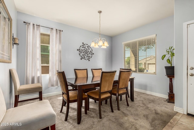 dining room featuring baseboards, a chandelier, and light carpet