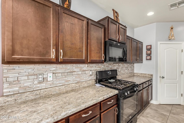 kitchen featuring light stone counters, tasteful backsplash, visible vents, black appliances, and dark brown cabinets