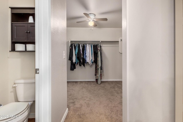 bathroom featuring toilet, baseboards, and ceiling fan