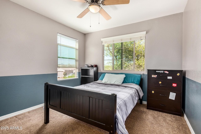 carpeted bedroom with baseboards, ceiling fan, and multiple windows
