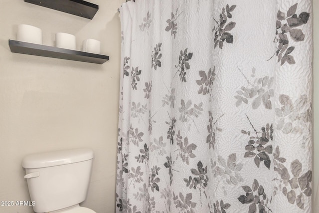 full bath with a shower with curtain and toilet