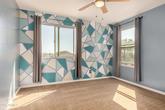 empty room with baseboards, carpet floors, and a ceiling fan