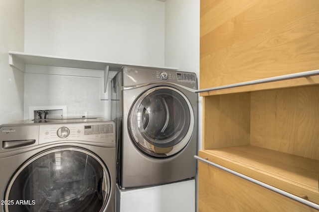 clothes washing area with washing machine and clothes dryer and laundry area