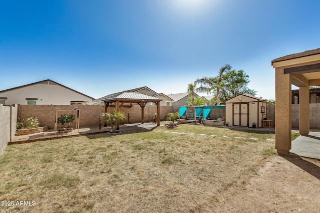 view of yard with an outdoor structure, a patio, a fenced backyard, a gazebo, and a storage shed