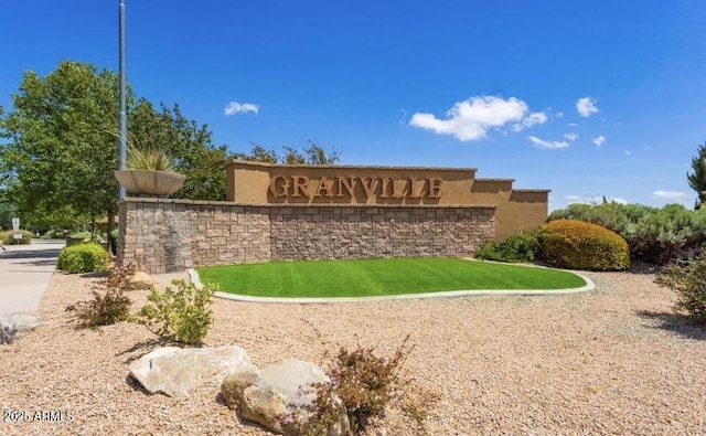 community / neighborhood sign featuring a lawn