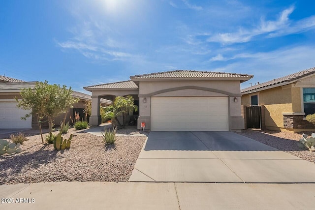 view of front of house featuring driveway, an attached garage, a tiled roof, and stucco siding