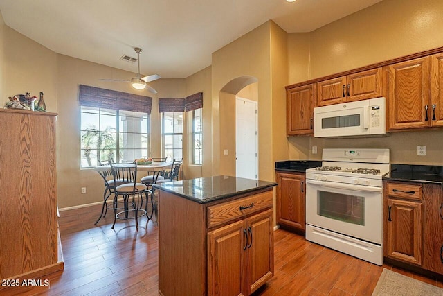 kitchen featuring white appliances, light wood-style flooring, and brown cabinets