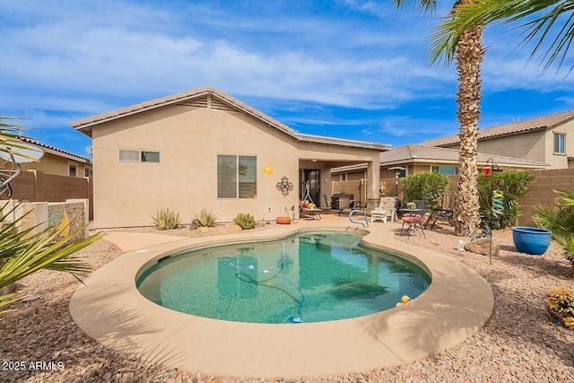 rear view of house with a patio area, a fenced backyard, and stucco siding