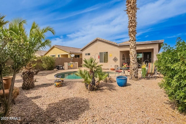 rear view of house with a fenced in pool, a patio, fence, and stucco siding